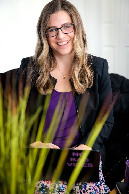 jill bilodeau behind plant with laptop