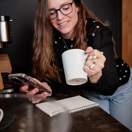 Jill Bilodeau on a phone call holding cup of coffee
